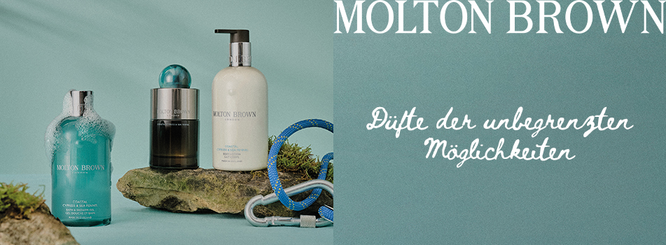 Werbung für Pflegeprodukte von Molton Brown. Drei verschiedene Flaschen – darunter ein türkisfarbenes Duschgel, ein schwarzes Parfum und eine weiße Lotion mit Pumpspender – stehen auf moosbedeckten Steinen vor einem hellgrünen Hintergrund. Daneben liegt ein Kletterseil mit Karabiner. Rechts im Bild steht: 'MOLTON BROWN – Düfte der unbegrenzten Möglichkeiten'. Die Szene vermittelt Naturverbundenheit und Abenteuer.