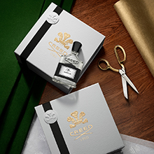 Creed Aventus Parfum mit Geschenkbox, Schere und Verpackung auf Holztisch