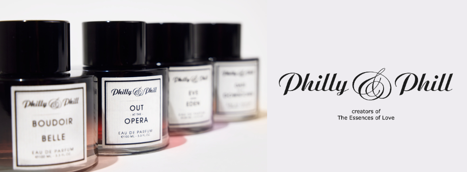 Markenbanner von Philly & Phill mit vier Parfumflakons in einer Reihe, darunter Boudoir Belle, Out at the Opera, Eve in Eden und ein weiteres Parfum. Rechts daneben das Logo von Philly & Phill mit dem Schriftzug ‚creators of The Essences of Love‘.